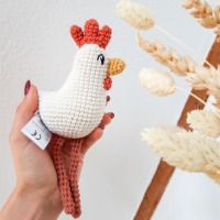 Babyrassel und Kuscheltier Huhn