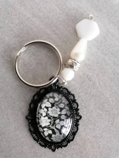 Schlüsselanhänger, mit Perlen und Amulett, silberfarben, Blume schwarz