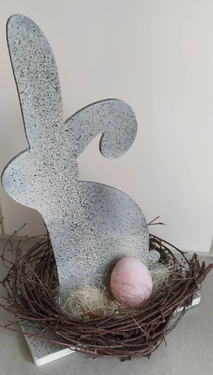Osterhase mit rosa-grauen Eiern