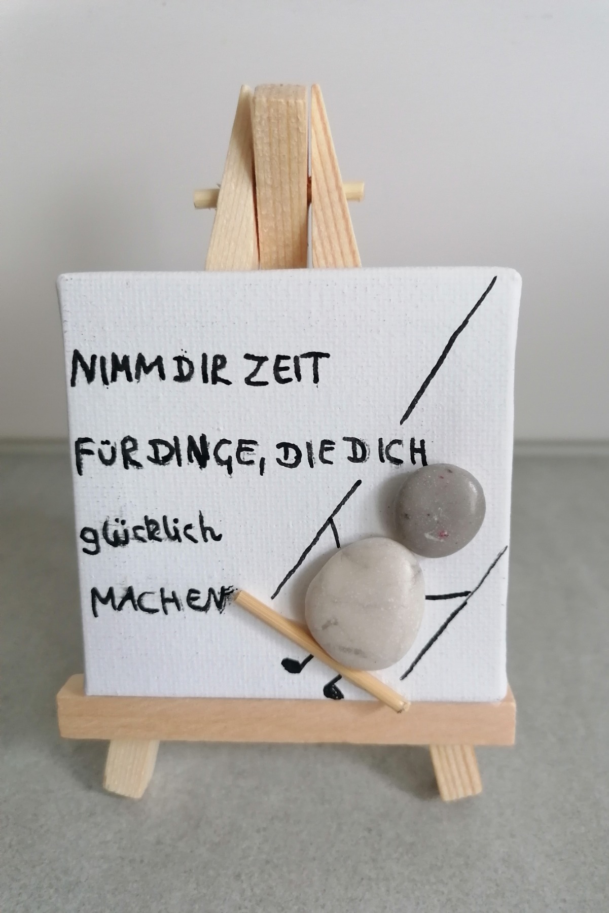 Leinwand auf Staffelei mit Spruch und Steinebild