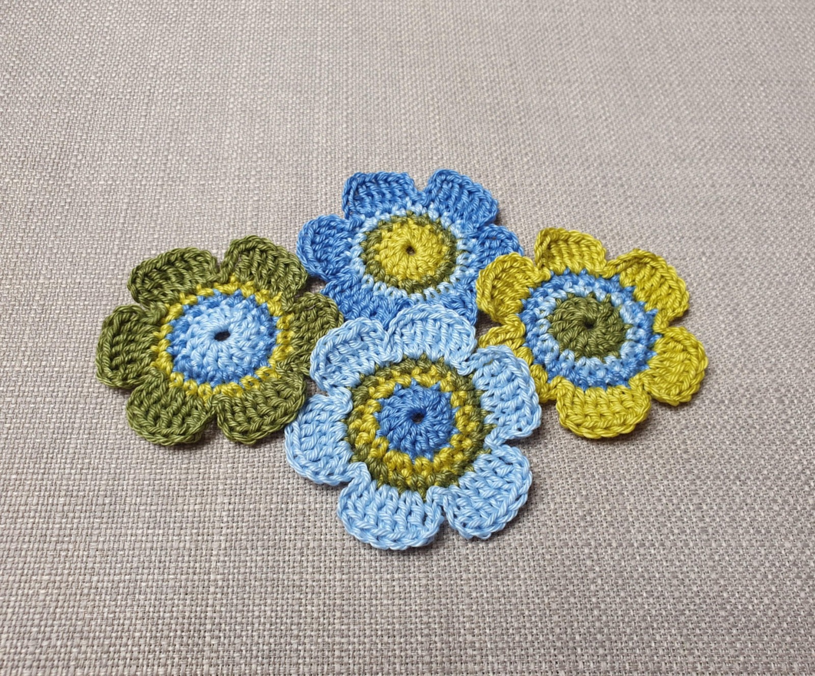 Handgefertigte 4er-Set Häkelblumen in Blau- und Grüntönen