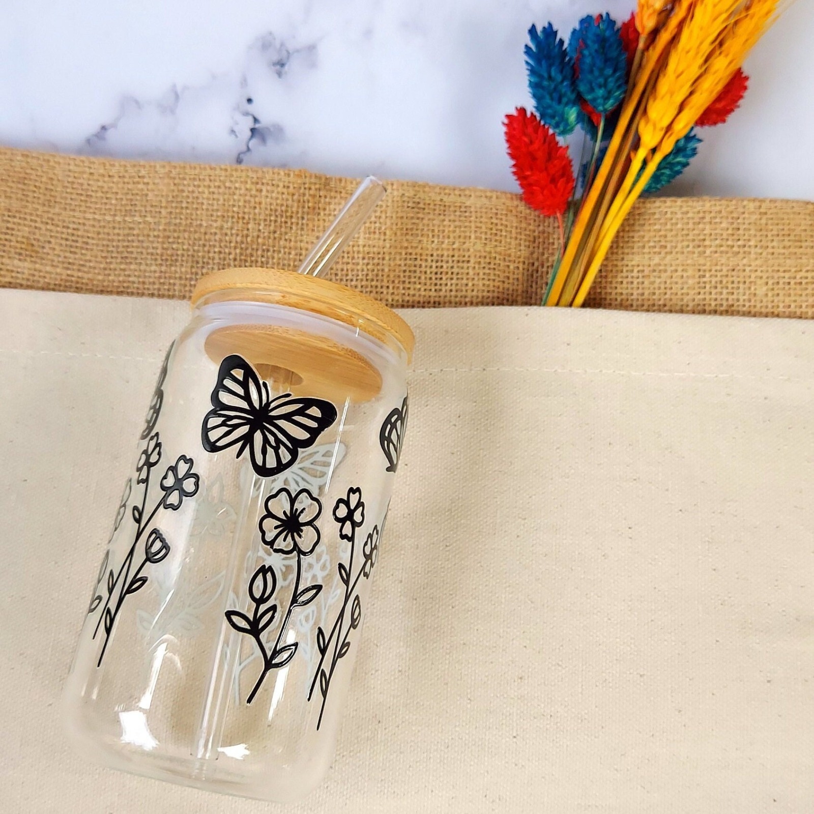 Trinkglas im mit minimalistischen Wildblumen und Schmetterlingen- Glas mit Bambusdeckel und Strohhal