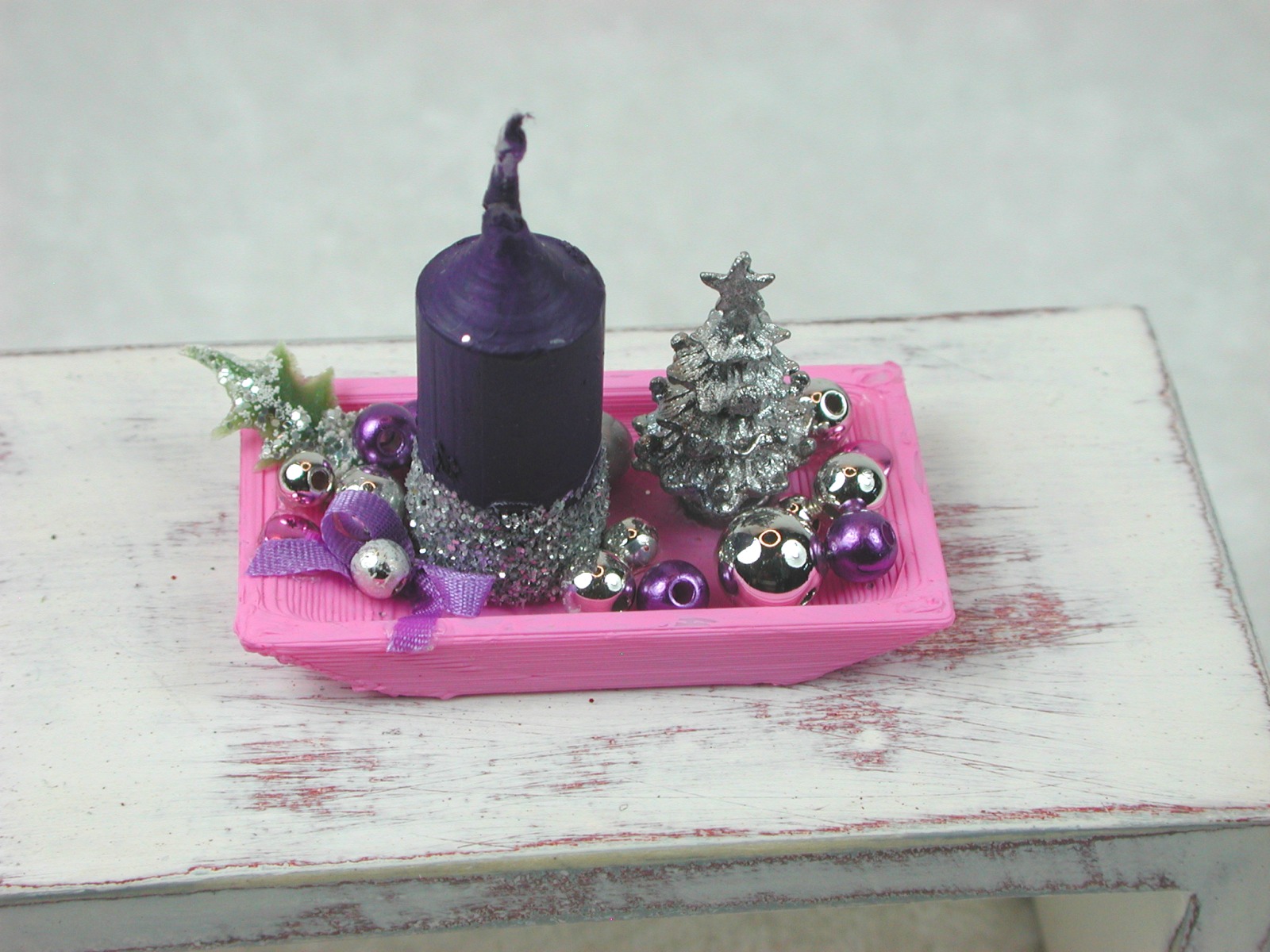 Rechteckige rosa Kunststoffplatte mit hochgebogenen Seiten mit violetter Kerze in weihnachtlicher De