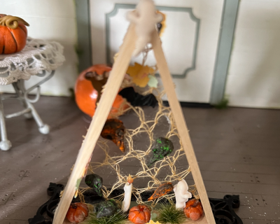 Dreieck aus Holz mit Kürbis, Kerze , Geist, Kröte und Herbstlaub zur Dekoration in der Puppenstube