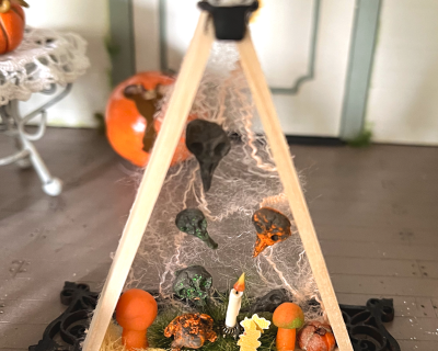 Dreieck aus Holz mit Kürbis, Pilze, Kröte und Herbstlaub zur Dekoration in der Puppenstube -
