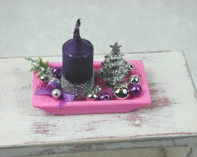 Rechteckige rosa Kunststoffplatte mit hochgebogenen Seiten mit violetter Kerze in weihnachtlicher