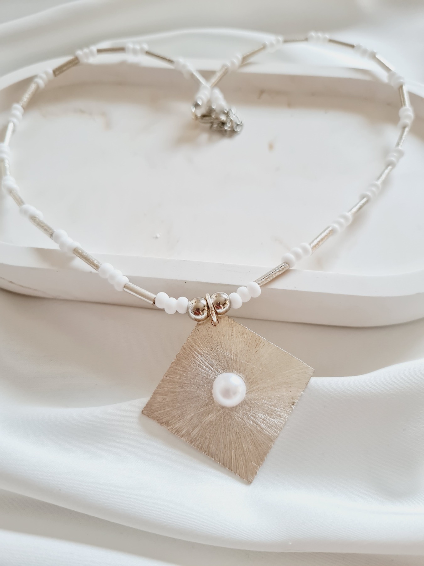 Halskette aus Rocailles Perlen in weiß mit Metall-Anhänger
