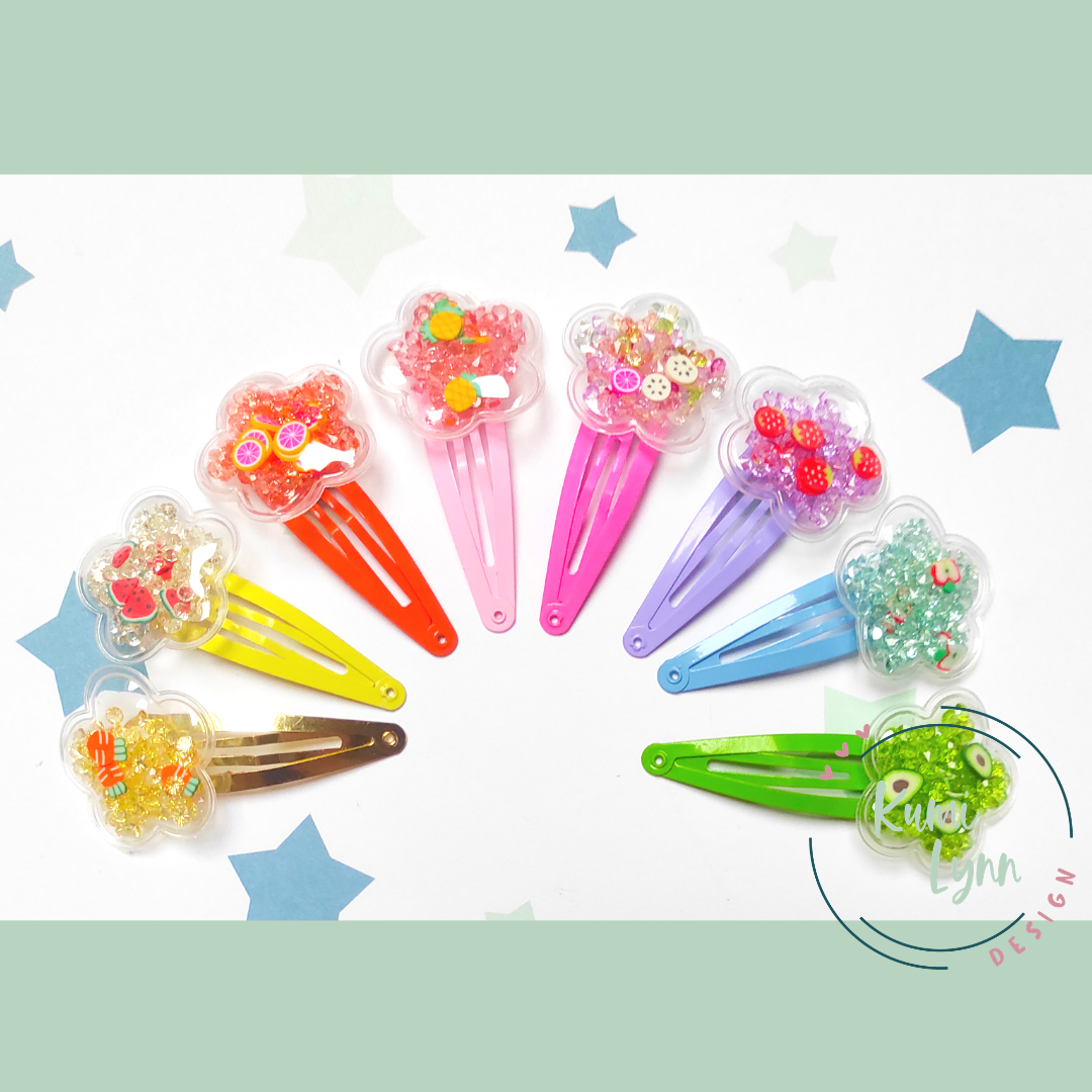Haarspange mit Blume aus Kunststoff gefüllt mit Glitzer und kleinen Früchten